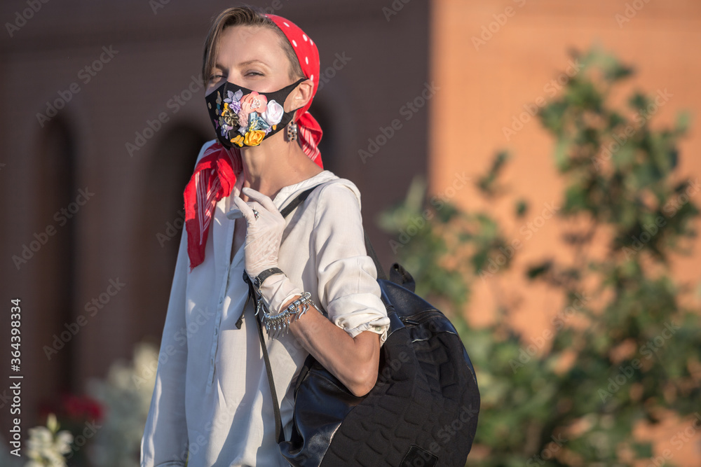 Woman in trendy fashion outfit during quarantine of coronavirus outbreak. Quarantine city lifestyle, young woman wearing protective mask and gloves on hands