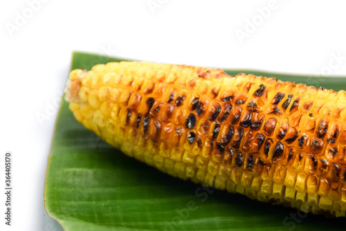 Roasted grilled corn with banana leaf on white background