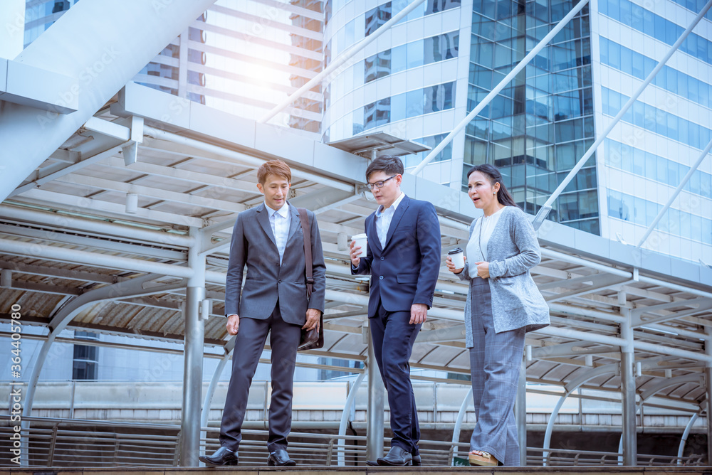 Business people talking and discussion about work when walking outside office at break time from office.