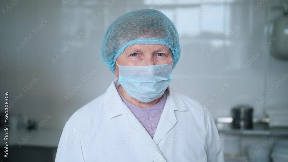 Elderly female doctor with blue eyes is looking at the camera. Elderly female doctor with blue eyes is looking at the camera.