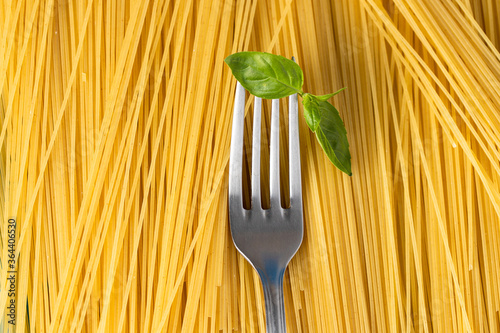 Close up of Italian Spaghetti texture with fork and basil. Utalian food concept.