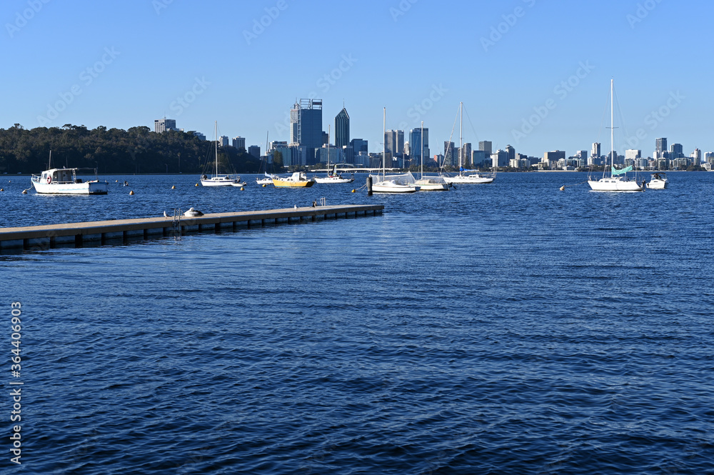 Sail boats mooring on Swan River against Perth financial district
