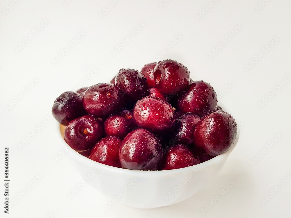 Bright juicy red cherry on a white background in drops of water. Bright juicy red cherry on a white background in drops of water.
