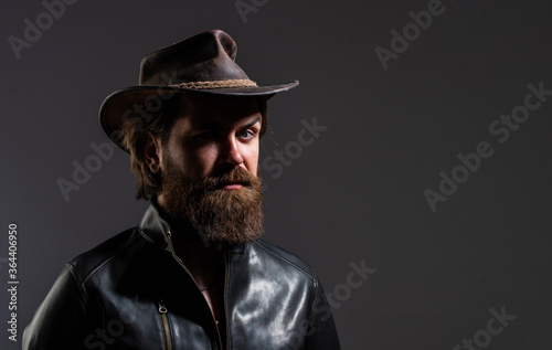 western man wear leather. modern west lifestyle. serious brutal bearded man. handsome and successful man in cowboy hat. He is in leather jacket. stylish successful man biker
