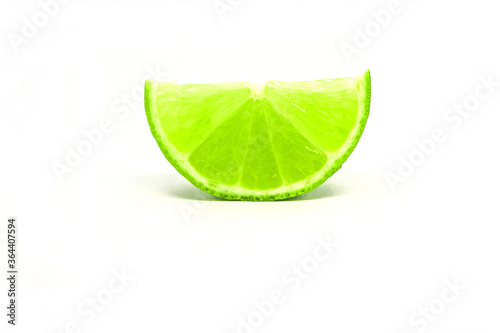 sliced piece of green fresh lime on white background isolated. 