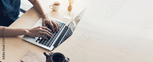 using computer.hand typing keyboard laptop online chatting search form internet while working sitting at coffee shop.concept for.technology device contact communication business people