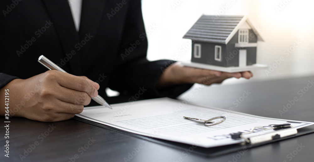 Fototapeta premium saleswoman gave the keys and house to the customer who signed the purchase contract.