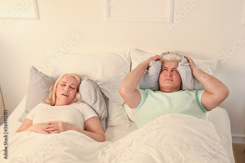 Mature irritated man in bed...