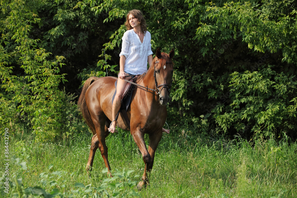 Beautiful young girl with blond hair in a jacket with a shorts, smiling and riding her horse. Equestrian, lifestyle. Beautiful young girl with blond hair in a jacket with a shorts, smiling and riding her horse. Equestrian, lifestyle.