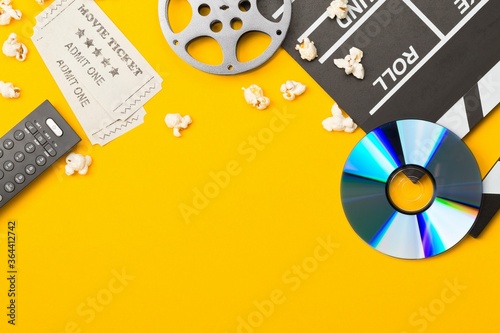 Valokuva Movie clapper or clapper-board with dvd movie disc, film reel, popcorn, remote c
