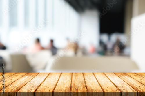 Empty wooden desk space and blurry background of cafe or Restaurant for product display montage.