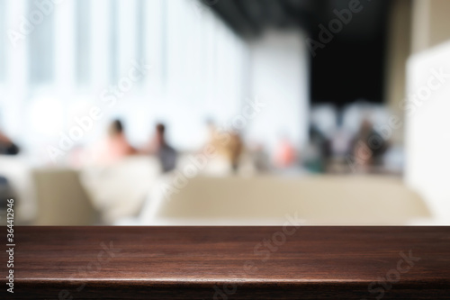 Empty wooden desk space and blurry background of cafe or Restaurant for product display montage.