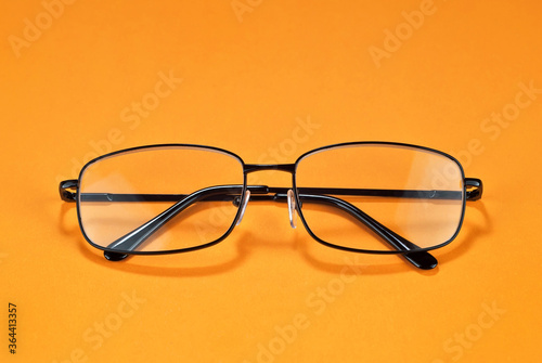 Different types of glasses on a yellow background close up. Glasses with rectangular frames.