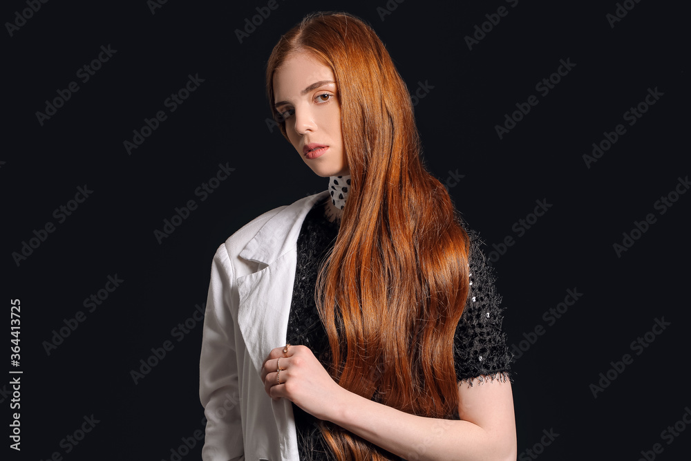 Naklejka premium Beautiful young redhead woman on dark background