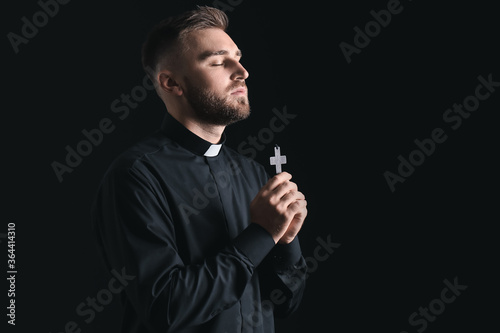 Young priest praying to God...