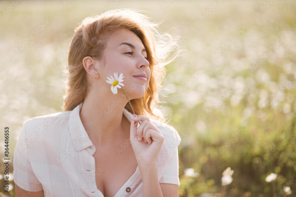 Young beautiful woman relaxing in chamomile field. Young beautiful woman relaxing in chamomile field.