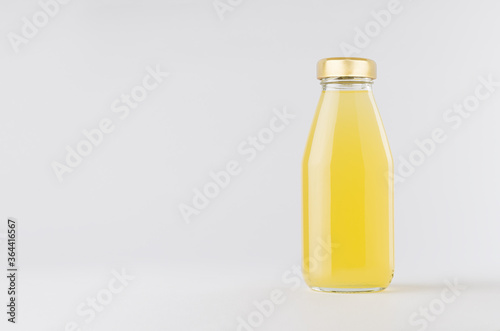 Yellow pineapple juice in glass bottle with gold cap mock up on white background with copy space, template for packaging, advertising, design product, branding.