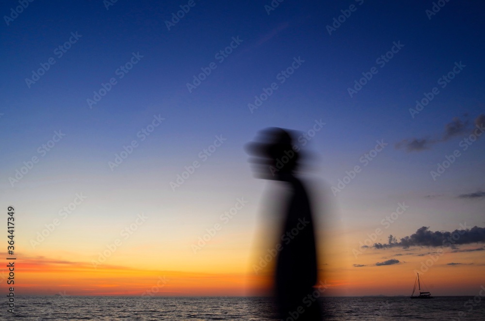Motion blurred silhouette of man on the beach at sunset background.Abstract picture. Motion blurred silhouette of man on the beach at sunset background.Abstract picture.