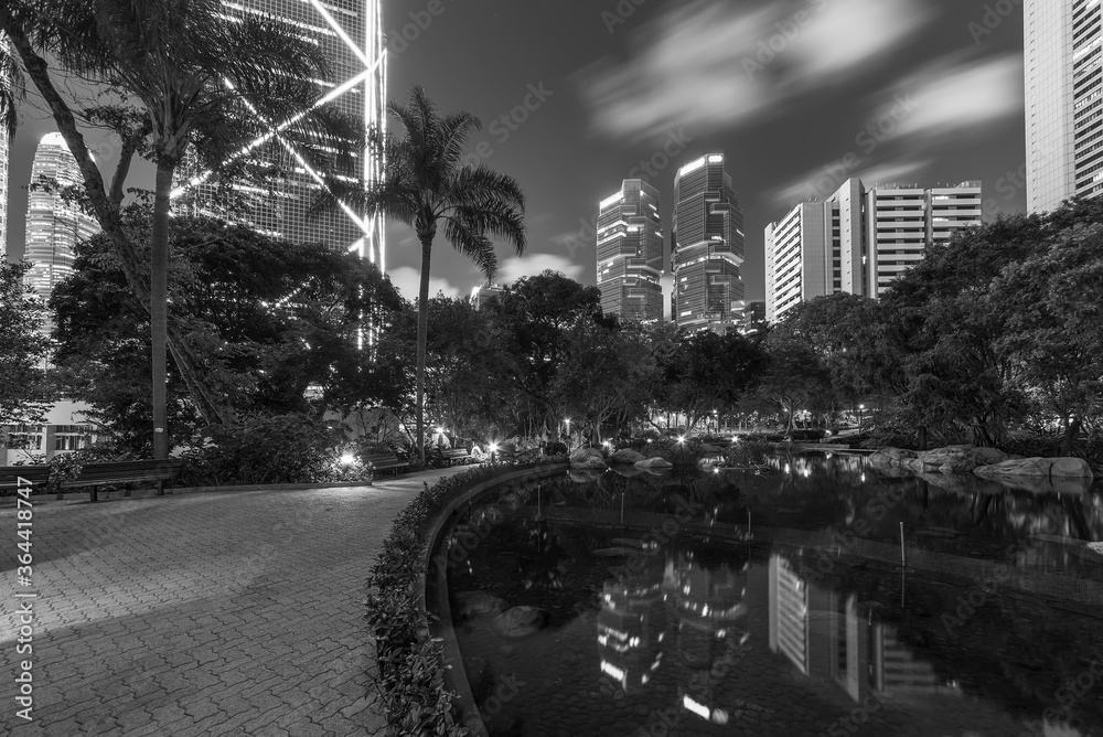 Naklejka premium High rise office building and public park in midtown of Hong Kong city at night