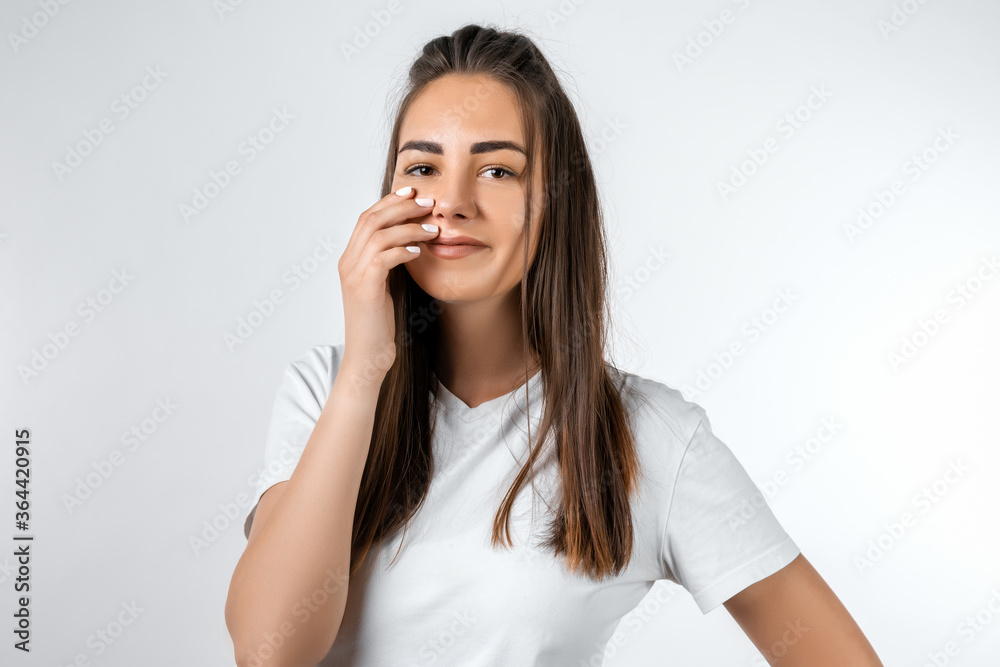 Young carefree modern girl with long chestnut hairs in casual light clothes posing isolated on white wall background. People lifestyle concept. Young carefree modern girl with long chestnut hairs in casual light clothes posing isolated on white wall background. People lifestyle concept.