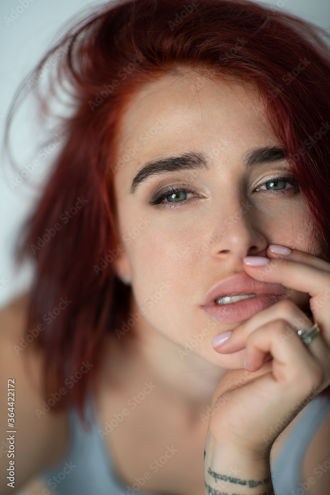Beautiful young ginger woman with freckles and blue eyes. Portrait of charming girl wearing casual clothes posing at home, looking at camera Beautiful young ginger woman with freckles and blue eyes. Portrait of charming girl wearing casual clothes posing at home, looking at camera