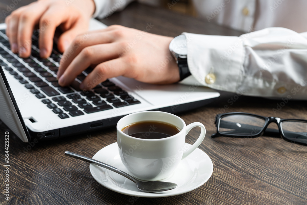 Businessman sitting at desk and using laptop Businessman sitting at desk and using laptop
