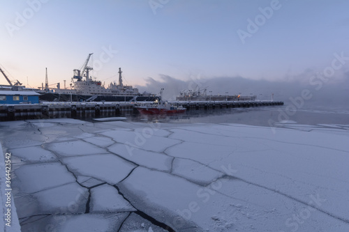 Berth, ships, ice floes in the seaport in winter. © Moroshka