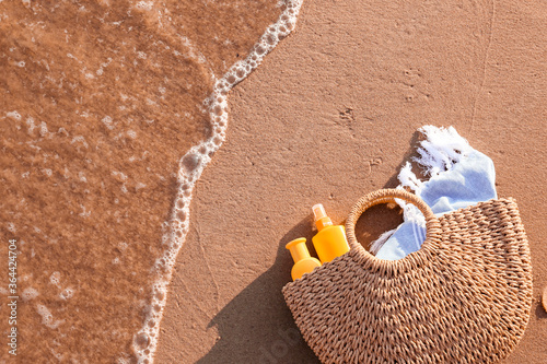 Bag with sunscreen cream on beach