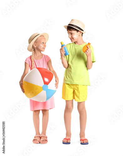 Little children with sun protection cream and inflatable ball on white background