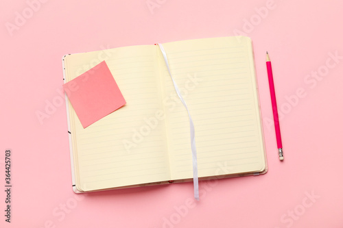 Stylish notebook with pencil on color background