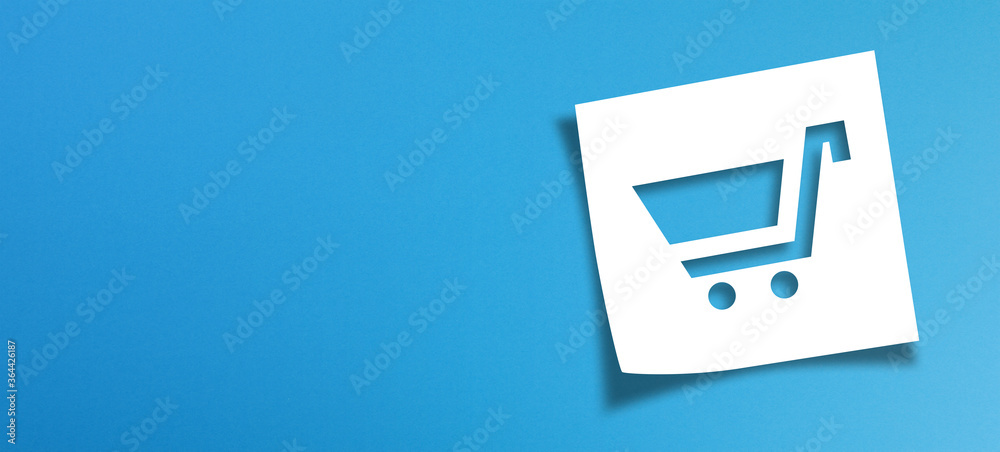 Note paper and shopping cart sign with copy space on panoramic blue background