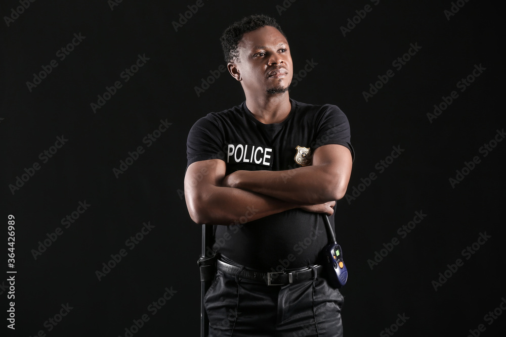 African-American police officer on dark background African-American police officer on dark background