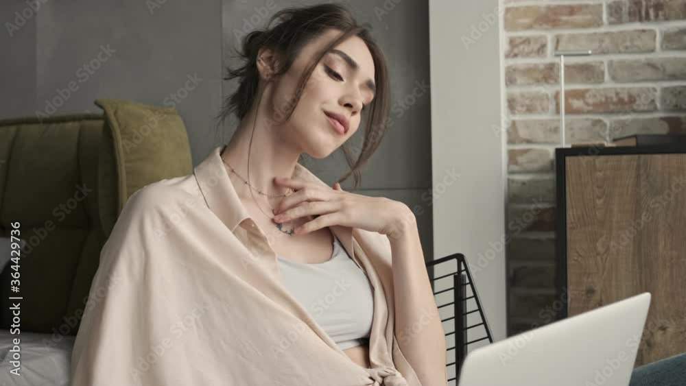 Young concentrated beautiful woman sitting indoors at home and using laptop computer Young concentrated beautiful woman sitting indoors at home and using laptop computer