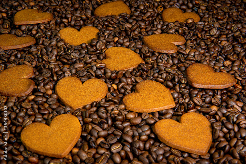 Heart-shaped gingerbread cookies on the coffee beans background Heart-shaped gingerbread cookies on the coffee beans background