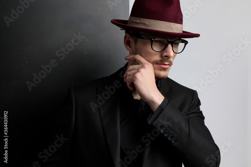 dramatic portrait of an elegant fashion guy touching his face
