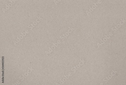 Sheet of brownish grey paper carton background with inclusions of recycled paper particles. Extra large highly detailed image. Recycled paper concept.