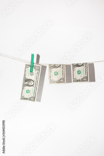 Money laundering - American dollars hanging on a string with pins