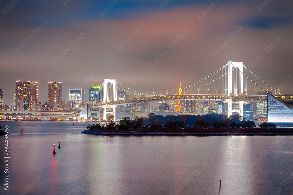 Tokyo Destinations. View of Rainbow Bridge in Odaiba Island in Tokyo At Twilight with Line of Skyscrapers in Background.