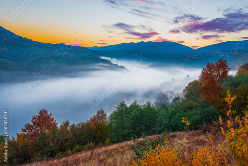 Beautiful morning landscape with autumn foggy mountains.