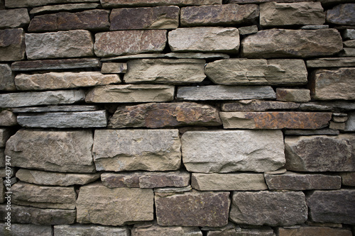 Hand built dry stone wall with different sized stones. Detail and texture.