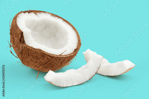 cracked coconut isolated on blue background with copy space, concept of tropical fruit and summer refreshments