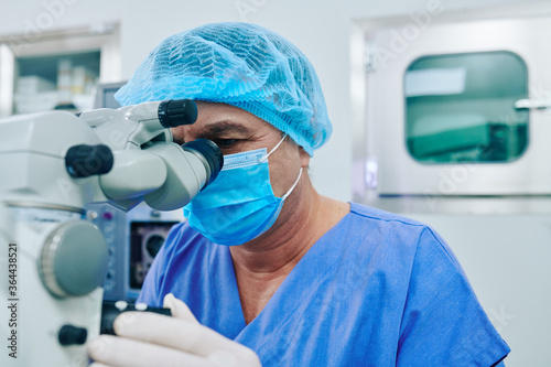 Experienced surgeon doing laser vision correction with help of modern equipment