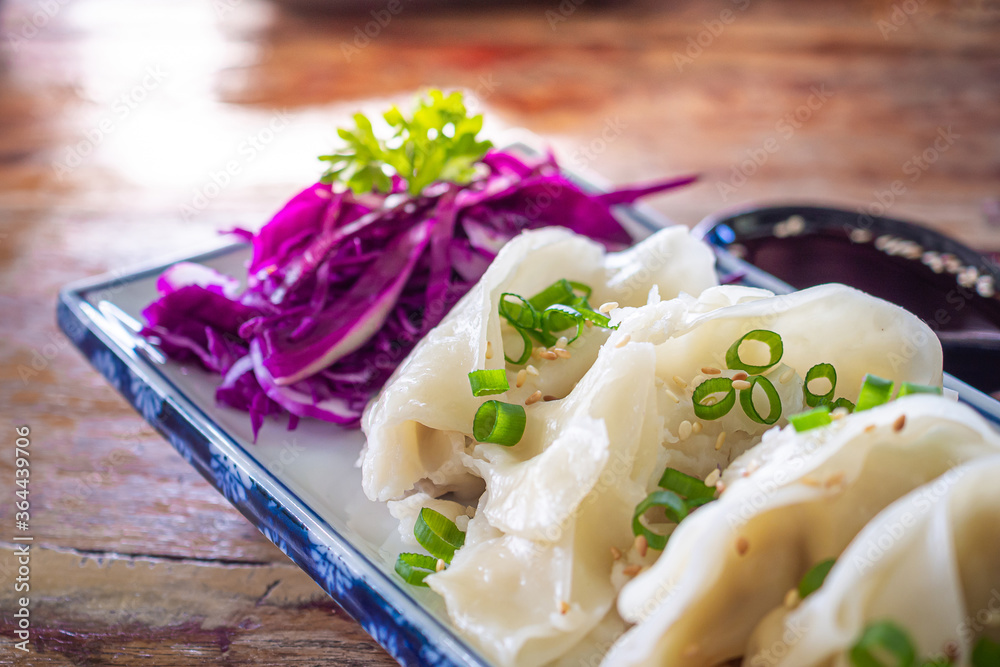 Side view of fresh Chinese dumplings or jiaozi on plate