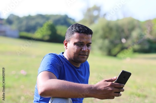 young smiling man looking at his mobile in happy mood