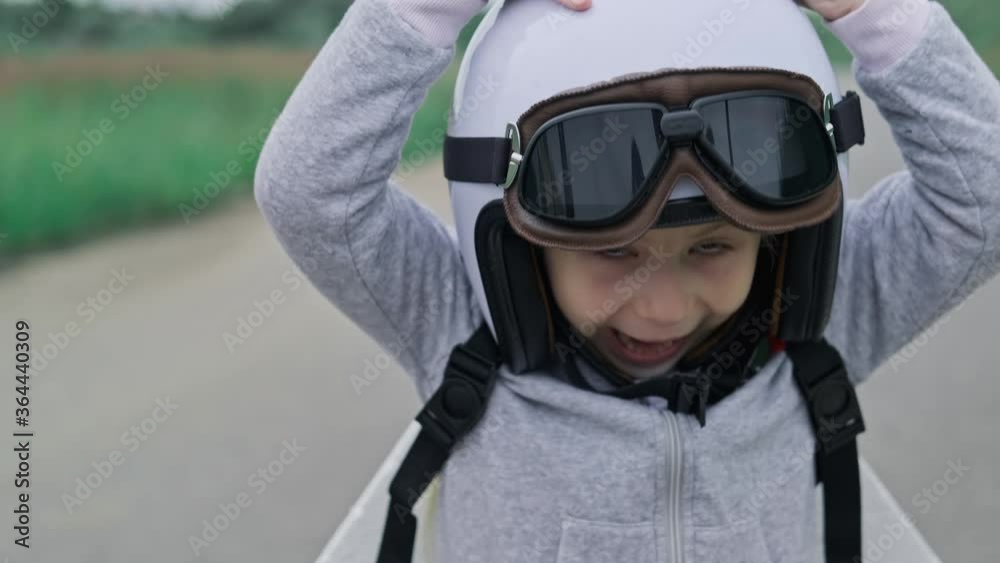 Little girl wearing protective glasses and helmet. Child putting on pilot glasses. Happy kid playing outdoors. Close up in 4K, UHD Little girl wearing protective glasses and helmet. Child putting on pilot glasses. Happy kid playing outdoors. Close up in 4K, UHD