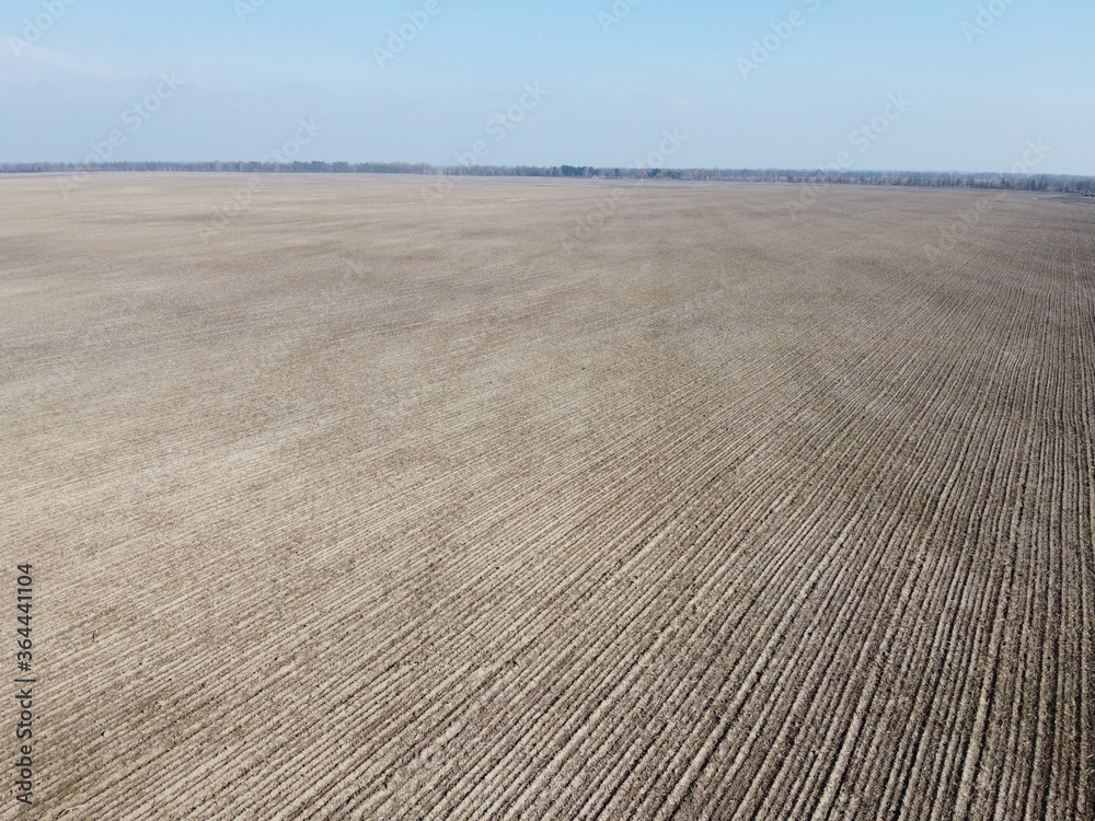 Agricultural fields on a sunny spring day, aerial view. Landscape. Blue sky over the fields. Agricultural fields on a sunny spring day, aerial view. Landscape. Blue sky over the fields.