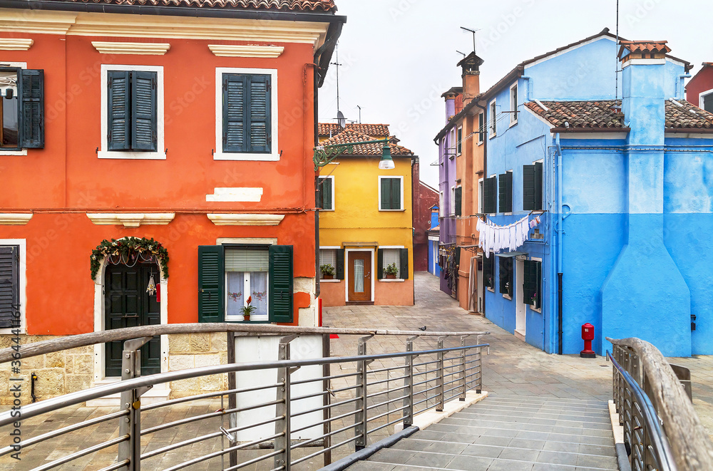 Welcome to the famous Burano island! Scenic view with bridge, colored houses and street in the Burano island. Italy.