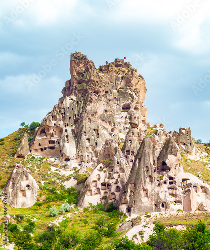 Uchisar Castle, carved from stone, stands next to fairy chimney rock formations in Uchisar, near the town of Goreme, in the Nevsehir Province of Cappadoica, Turkey photo