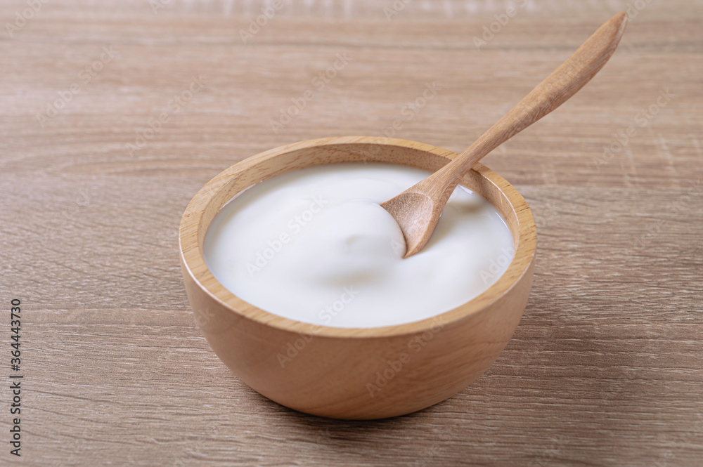 Homemade sour cream yogurt in wooden bowl on table. Homemade sour cream yogurt in wooden bowl on table.