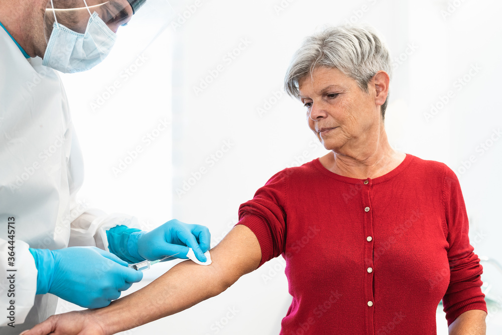 Obraz premium Doctor doing medical injection syringe vaccine to senior patient in hospital for preventing and stop corona virus outbreak - Healthcare medicine and cure against pandemic concept